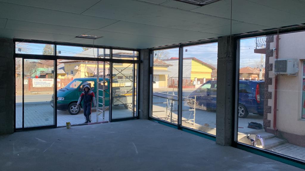 Interior de spațiu comercial cu vitraje mari din aluminiu, în curs de finisare